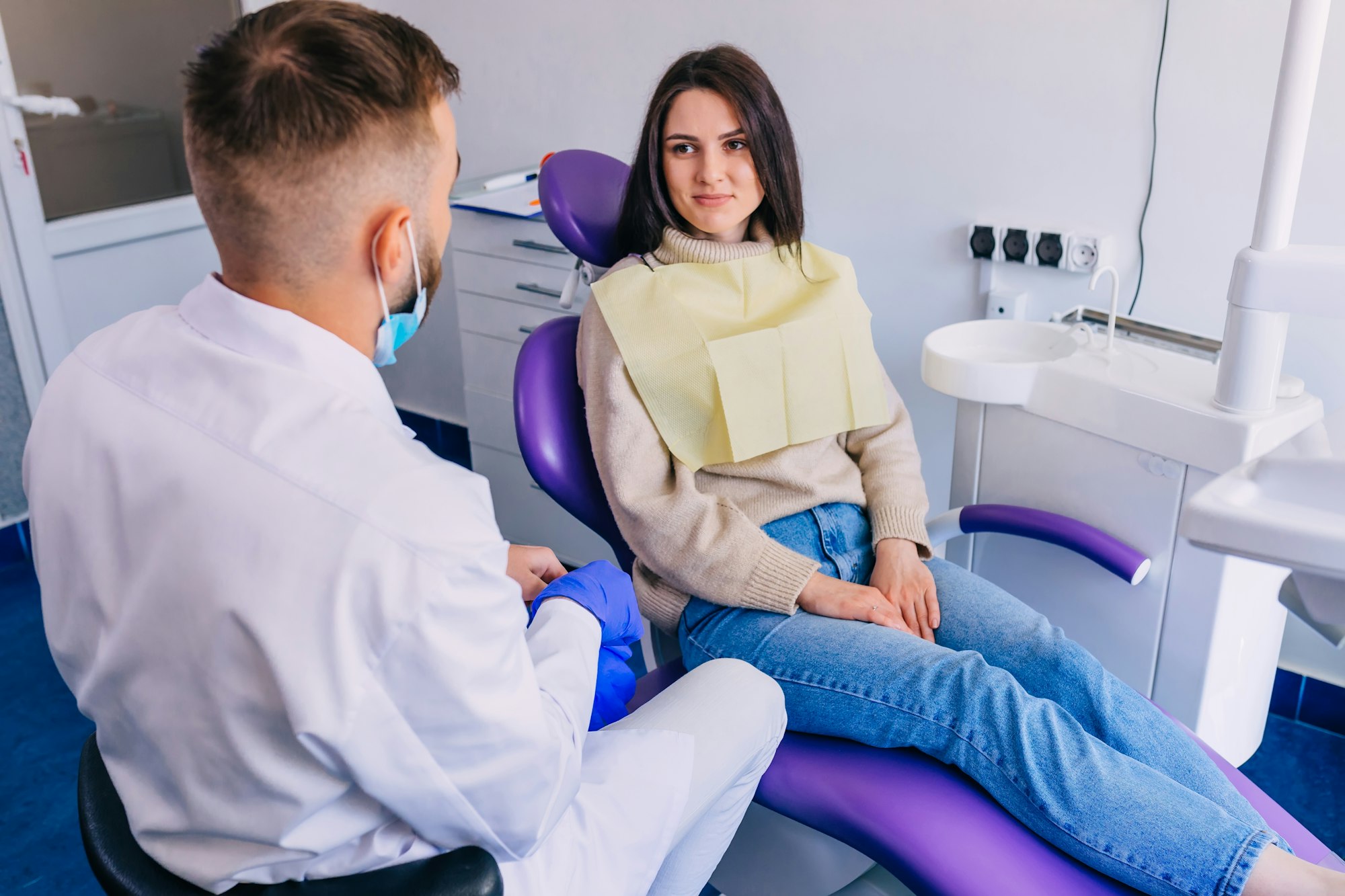 beautiful girl sitting in a chair and listening to an orthodonti