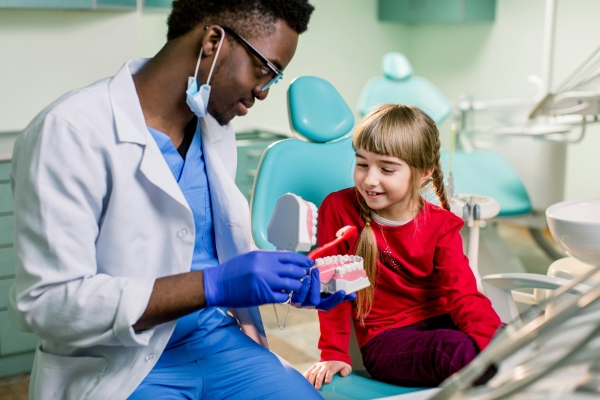 Dentist examines baby girl's teeth. Prophylaxis of caries, milk teeth, pediatrics